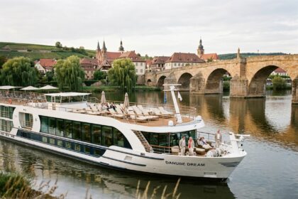 Bateau de croisière fluviale Rivages du Monde naviguant sur un fleuve européen avec terrasse panoramique et passagers en train de se détendre